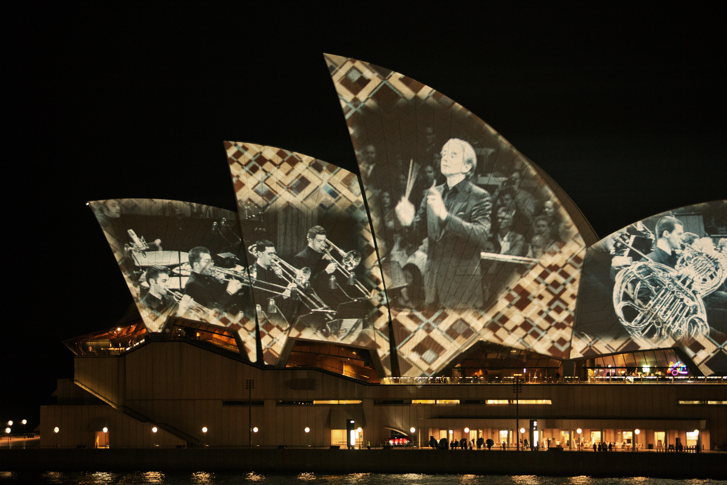 A night shot of the Sydney Opera House, illuminated by colourful lights. by Mario Zmudzinski at Magnum Studio