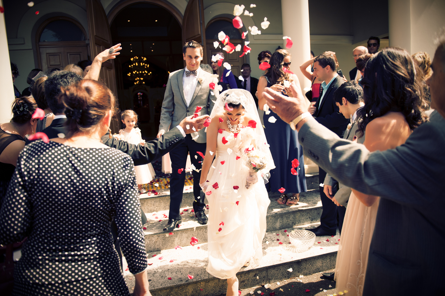 A joyful moment captured as bride, groom and guests throw flowers at the wedding.