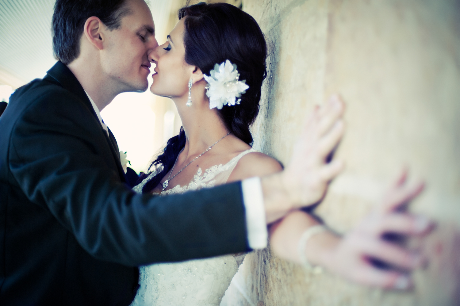 Happy couple share a kiss at their rustic farm wedding