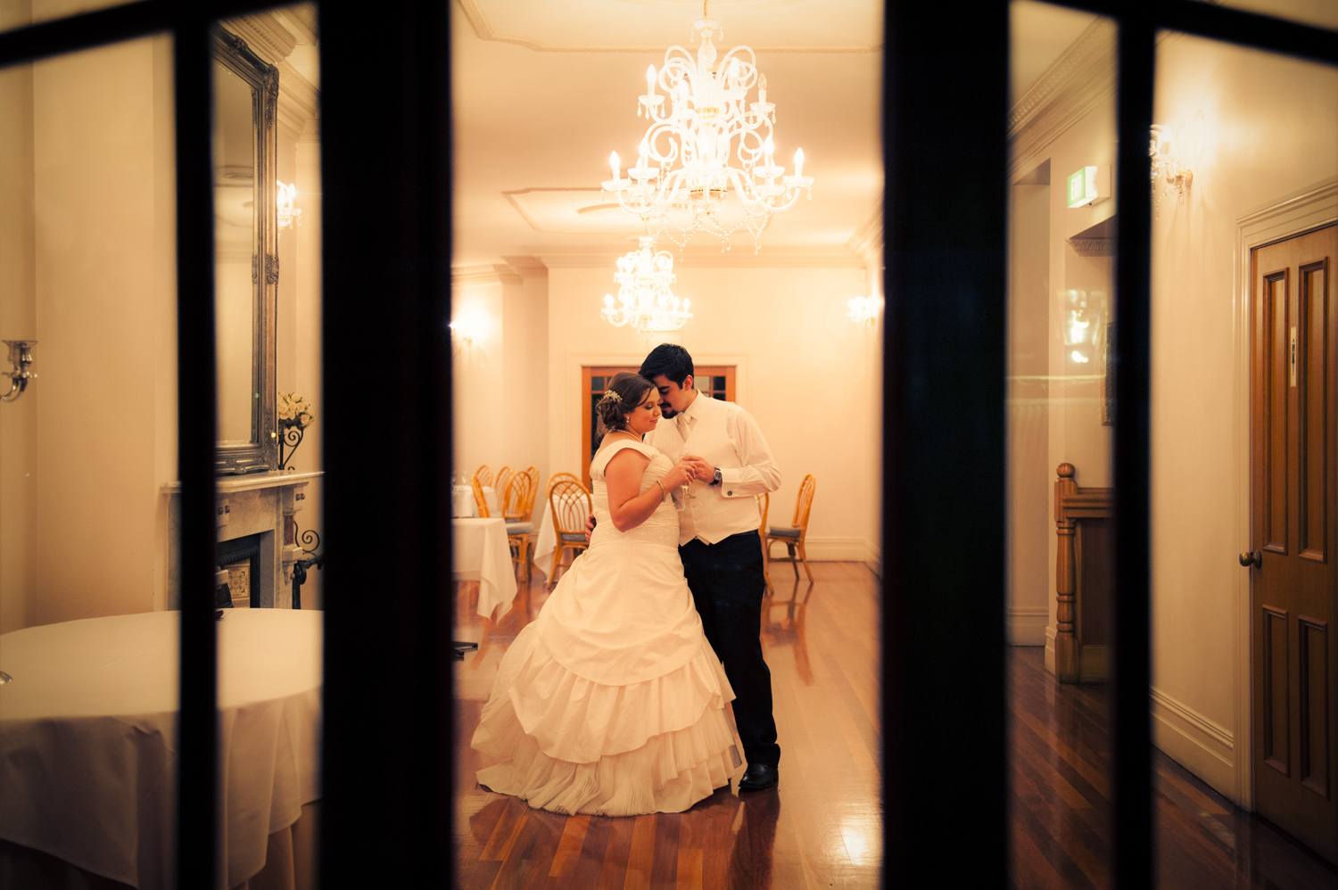 A bride and groom embracing on the dance floor during their wedding reception.