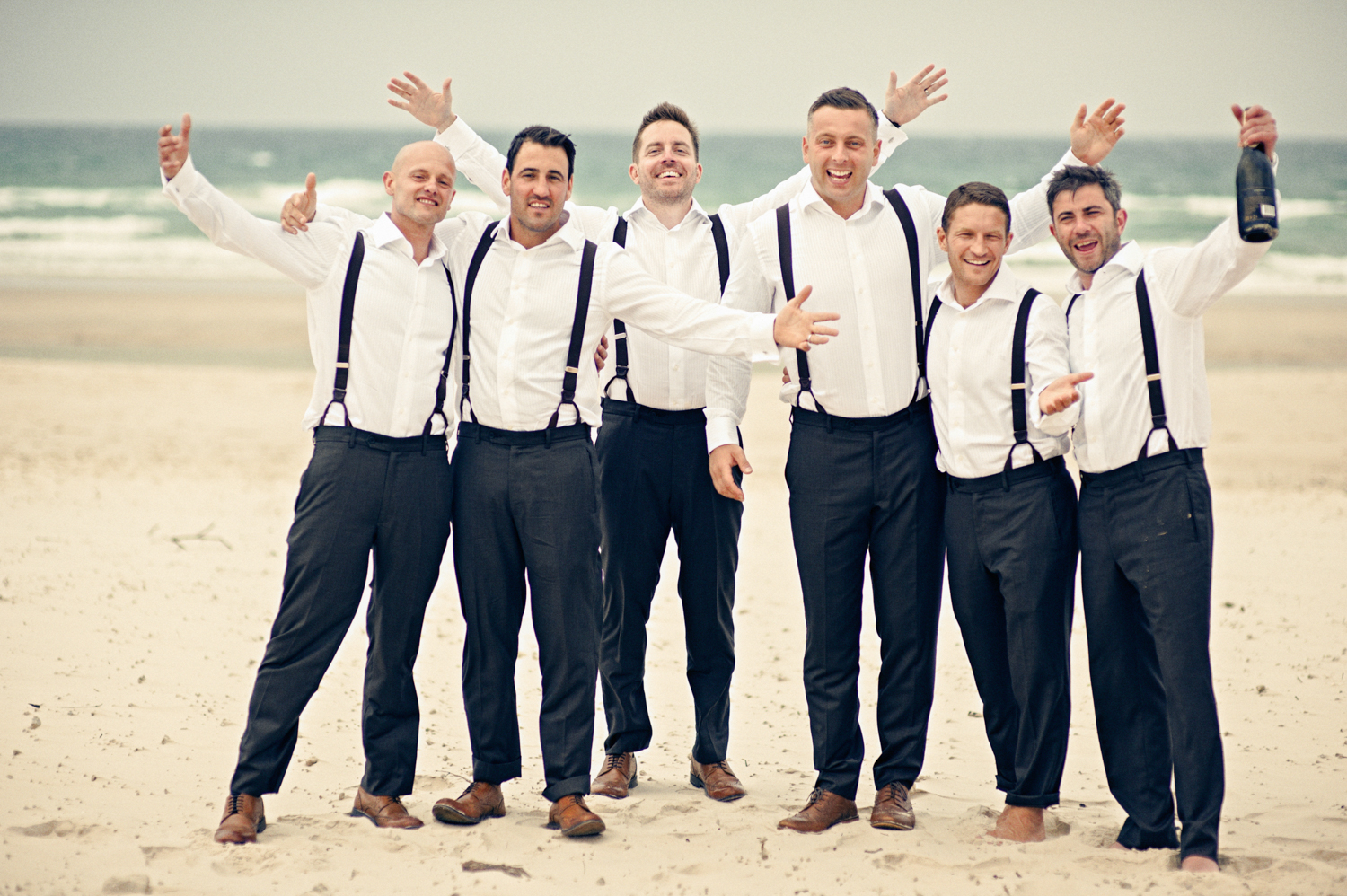 Groom and his best mates sharing a laugh on the beach on his special day