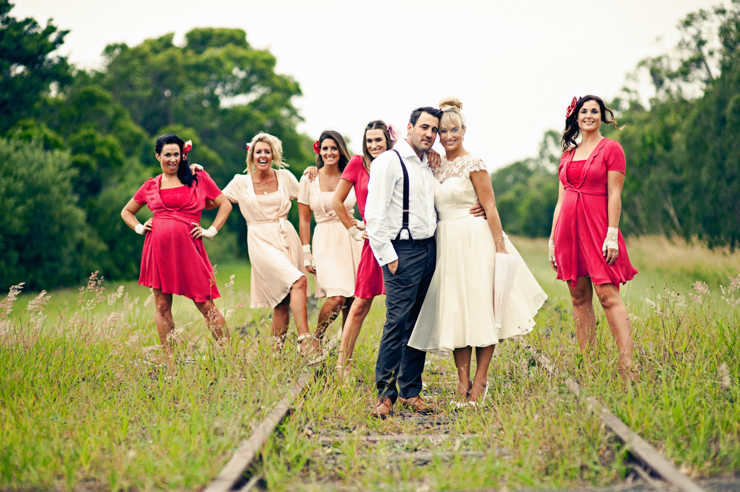 Happy newlyweds strolling on an old train track